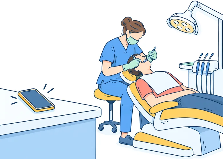 Ilustrație: un telefon sună pe biroul de la recepție, iar medicul stomatolog lucrează la un pacient în scaun și nu poate răspunde.